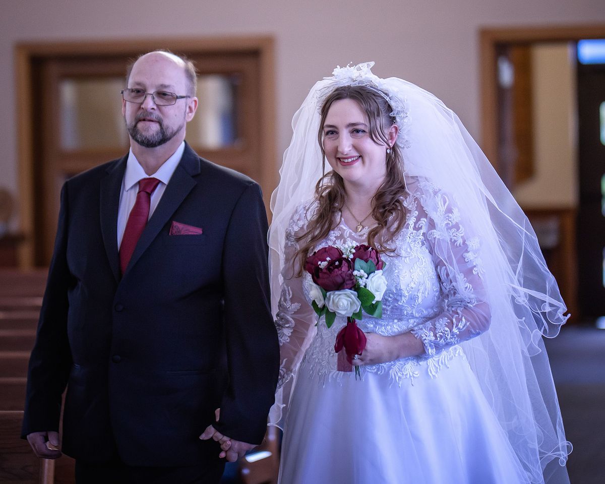 bride walking down the aisle with her dad for the wedding ceremony at st. lukes catholic church, lewes, delaware