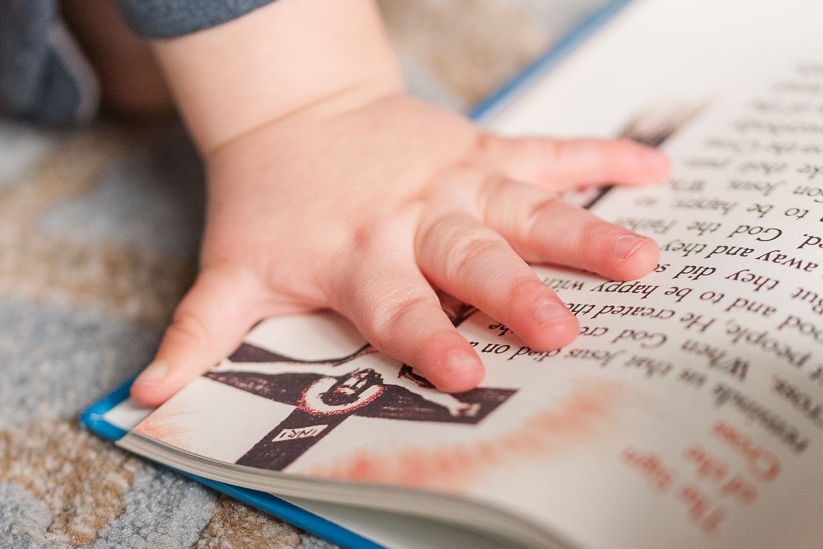 baby hand touching a picture of Jesus in a book, in Cranberry Township, PA